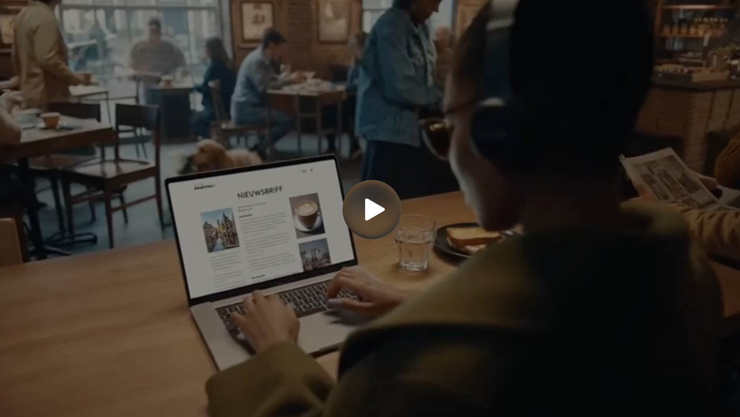 Persoon leest nieuwsbrief op laptop in café